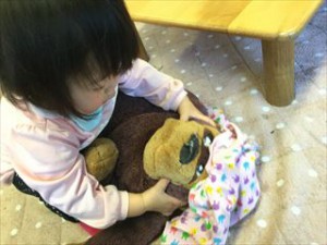 ゴリラのぬいぐるみに服を着せてあげようとしていました♡